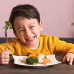 Anak tertawa bahagia sambil makan makanan bergizi untuk anak di rumah