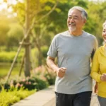Pasangan lansia sehat berjalan santai di taman sebagai ilustrasi healthy aging, gaya hidup aktif, kesehatan metabolik, dan longevity.